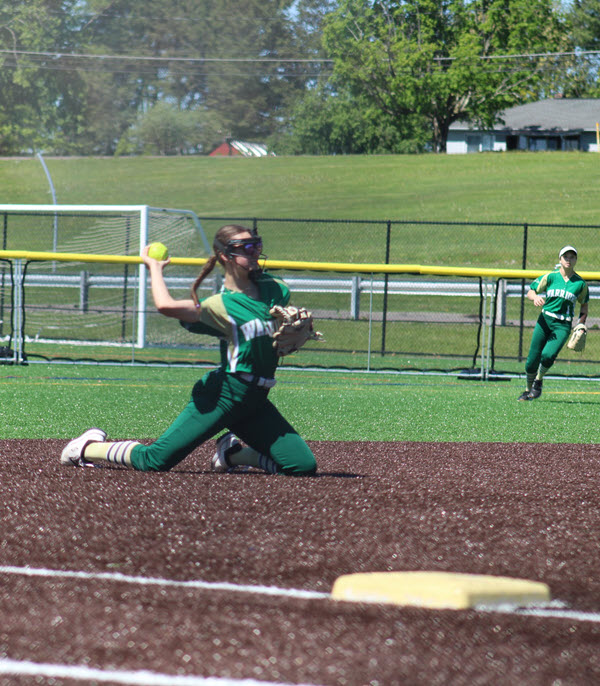 Addison throwing from her knees after a diving stop.